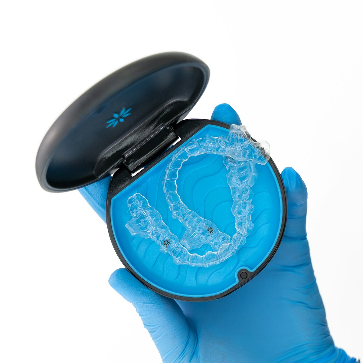 A person placing a clear aligner tray over their teeth