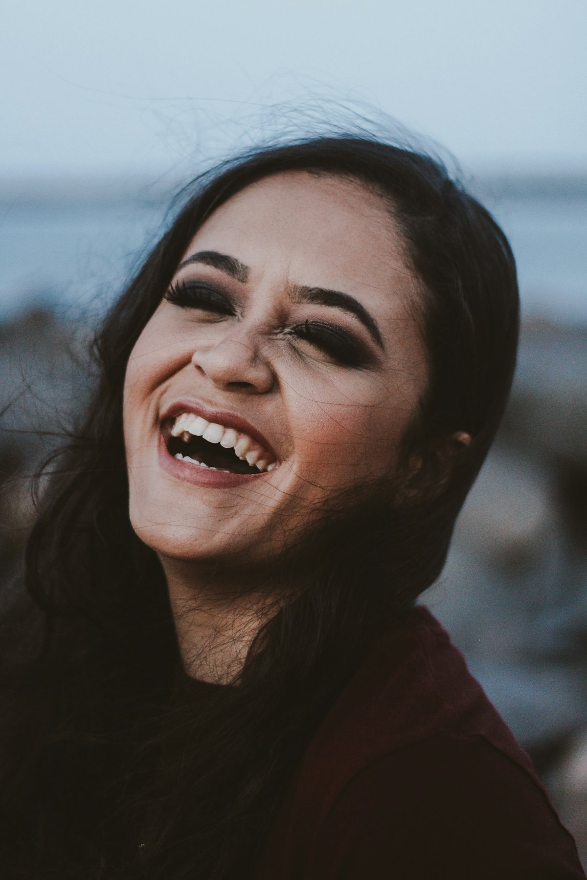 A person laughing with a confident smile
